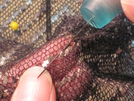 RubberTHIMBLE Davina repairing vintage assiut using a milliner's needle and a jelly thimble.